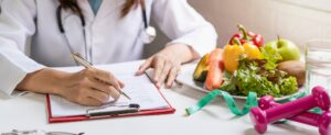 Nutritionist giving consultation to patient with healthy fruit and vegetable