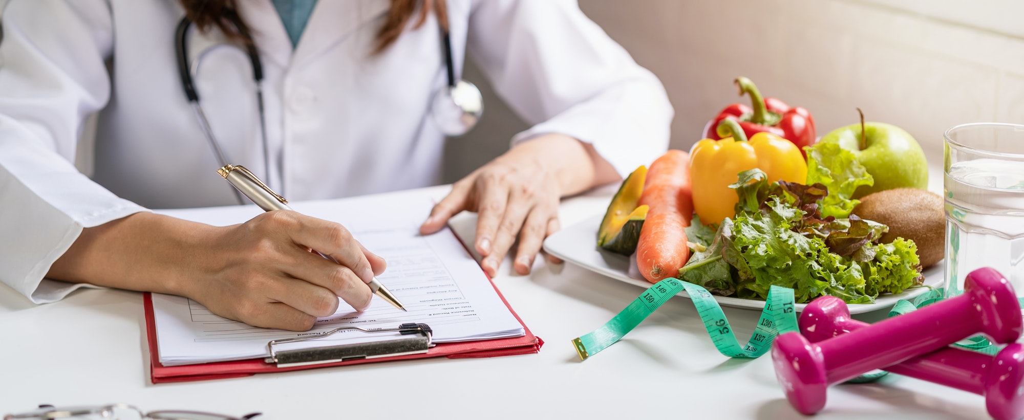 Nutritionist giving consultation to patient with healthy fruit and vegetable